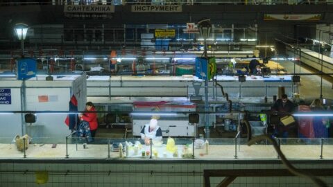 People working in a busy market at night.
