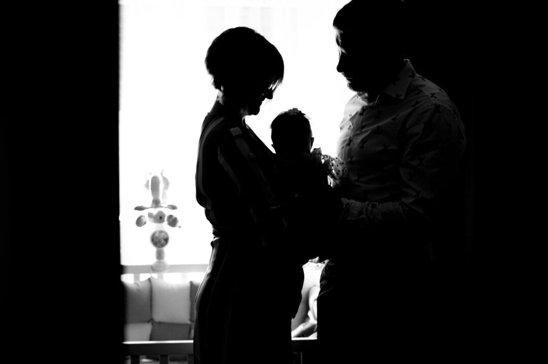 a black and white photo of a man holding a baby