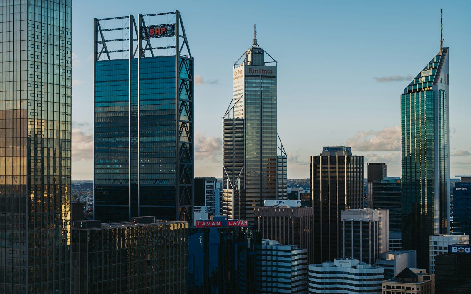 Modern skyscrapers dominate the city skyline at sunset.
