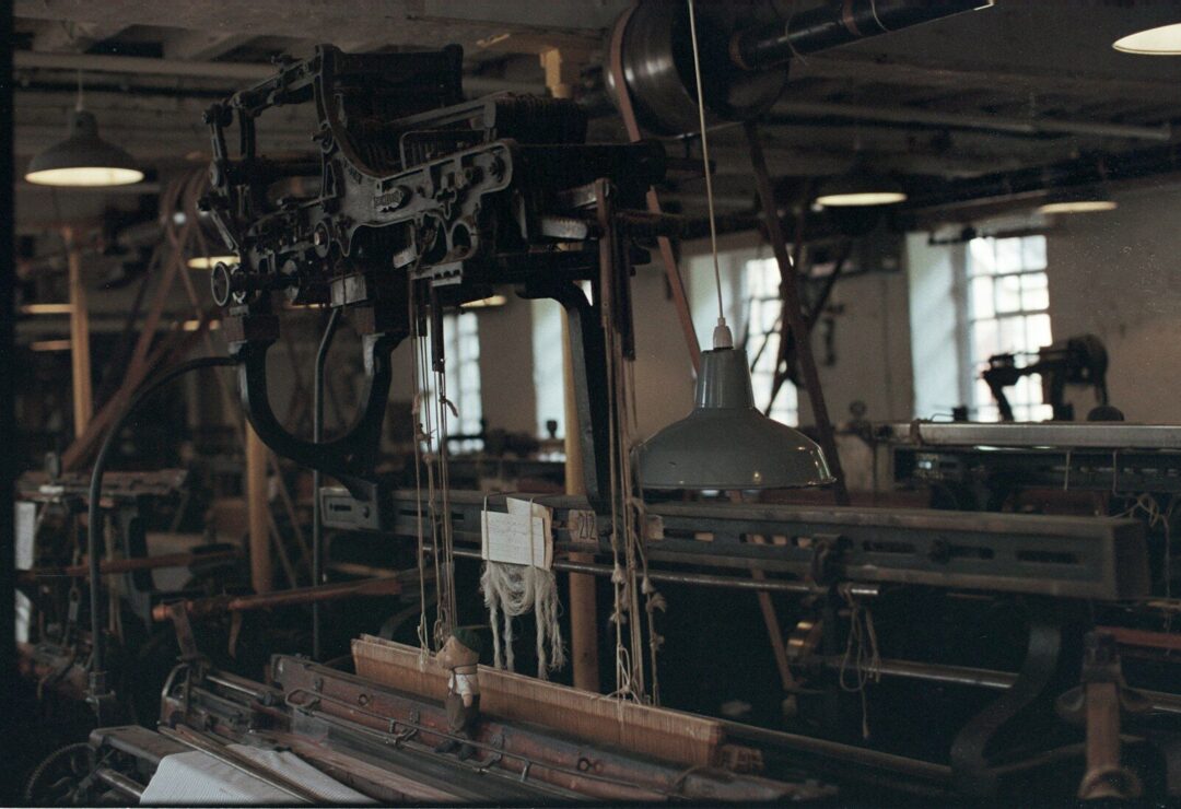 Antique industrial looms in a dimly lit workshop.