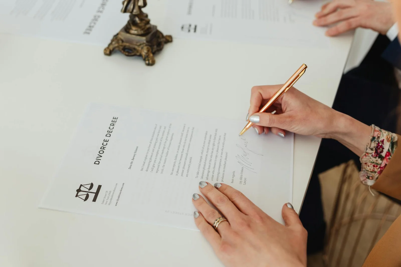 Arbitration Cannot Be Founded on Unilateral - Close-up of hands signing a divorce decree document on a desk, showcasing legal