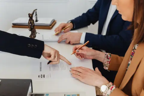 Boundary Disputes and Civil Court Jurisdiction: - Hands signing a divorce decree, with a justice statue nearby, symbolizing l