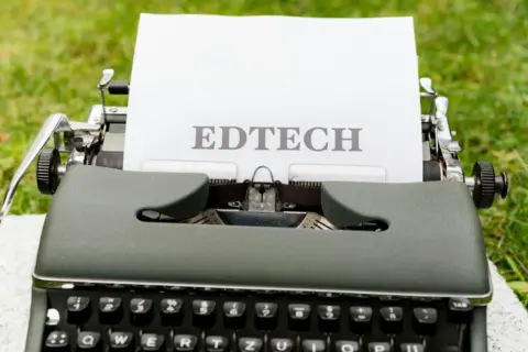 Dark Patterns in Ed-Tech: CCPA Imposes - A vintage typewriter displays 'EdTech' on paper, set outdoors on grass.