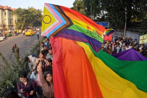 a group of people holding a rainbow flag - Delhi Transgender Rules 2025