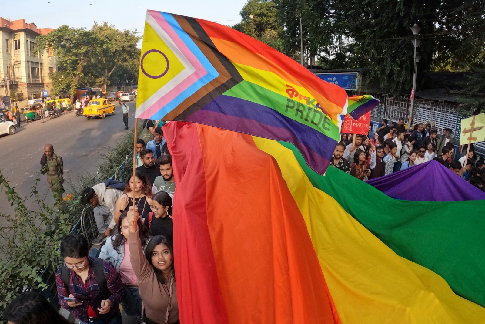 a group of people holding a rainbow flag - Delhi Transgender Rules 2025