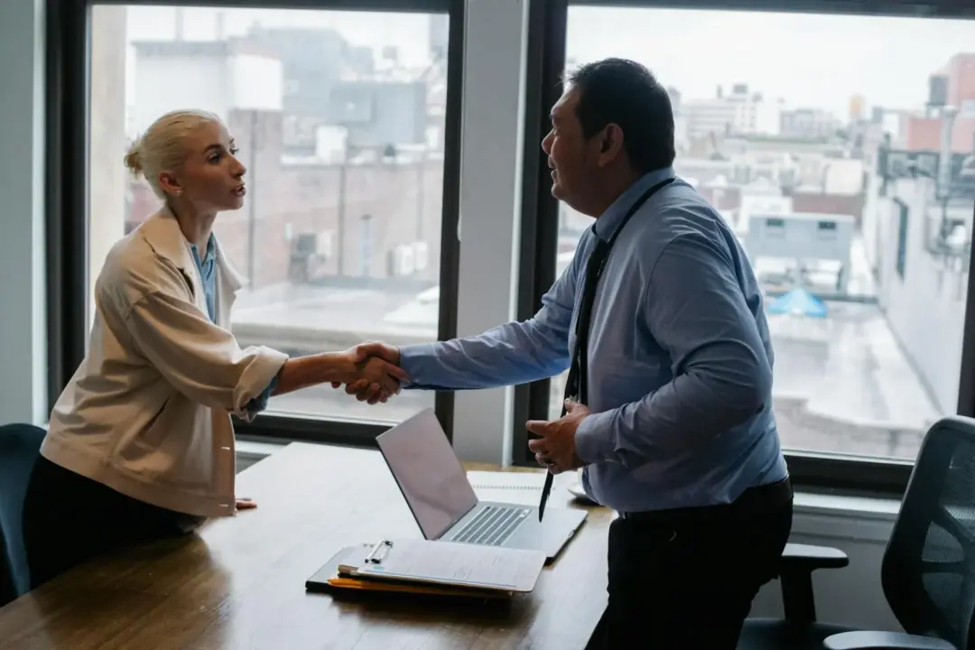 Employer-Employee Relationship as the Sine Qua - Young female candidate shaking hands with employer before job interview in l