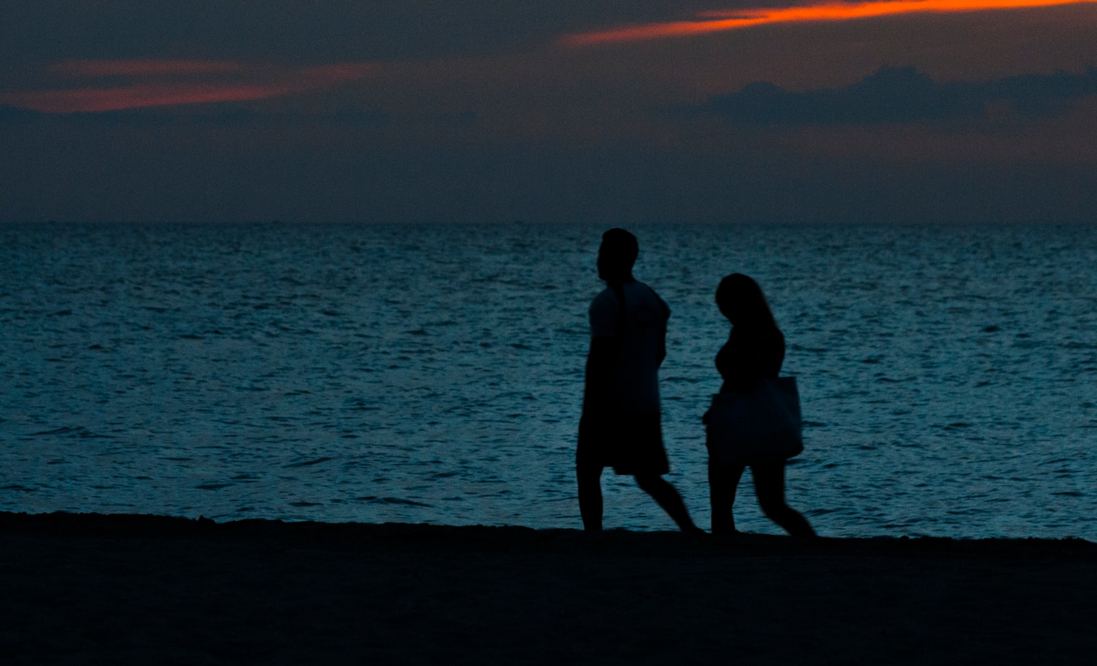 silhouette of two person walking beside beach - live-in relationship