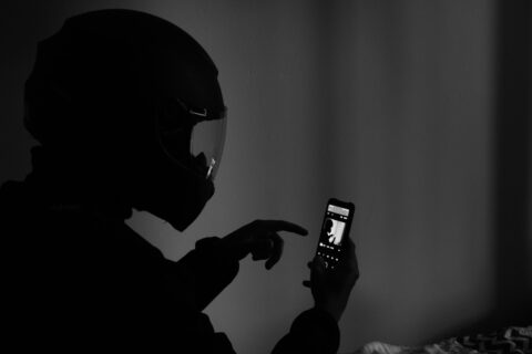 grayscale photography of man using smartphone - Digital Crime