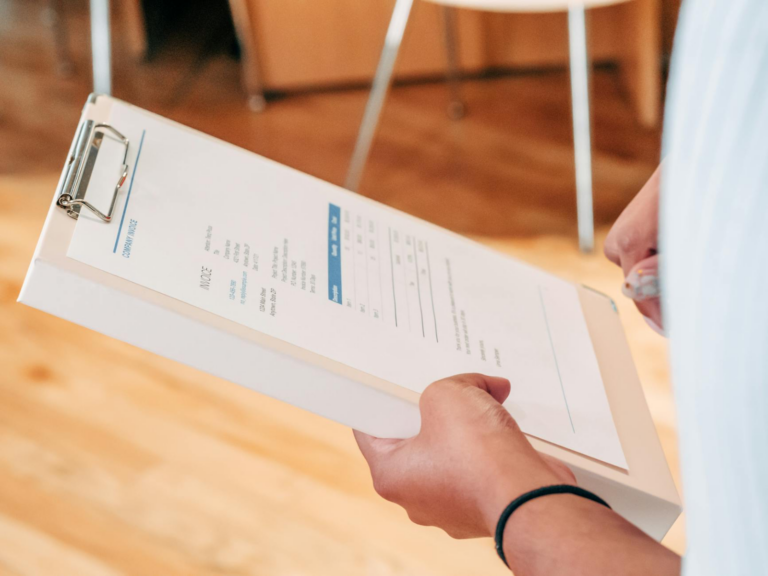 Invoice Requirements in Section 9 Petitions: - Close-up of hands holding a clipboard with business documents, indicating anal
