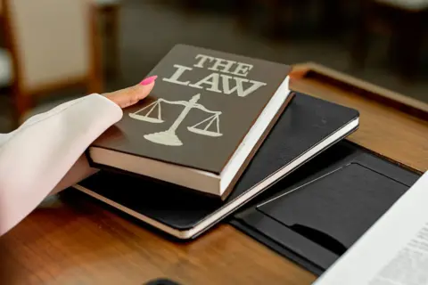 Judicial Restraint under Section 34: Delhi - Closeup image of a law book titled 'The Law' on a wooden desk with scales of jus