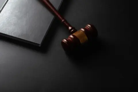 Judicial Review Vs. Electoral Continuity: Understanding - Wooden gavel resting on a dark surface next to book