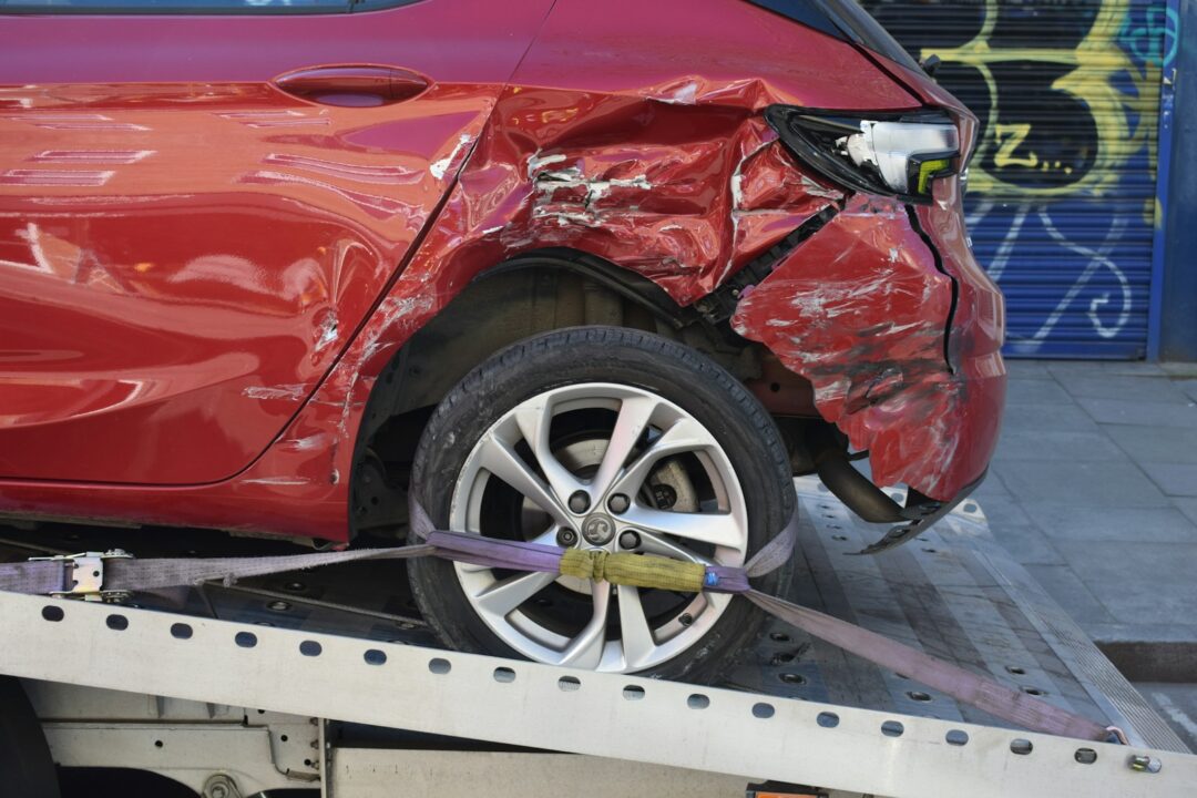 a red car is on a flatbed tow truck - No Insurance for Drivers Own Negligence