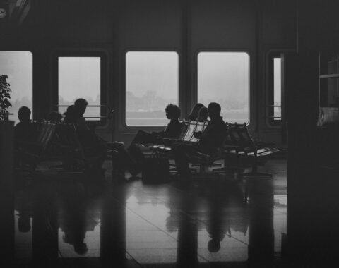 Silhouettes of people waiting by windows on a ferry