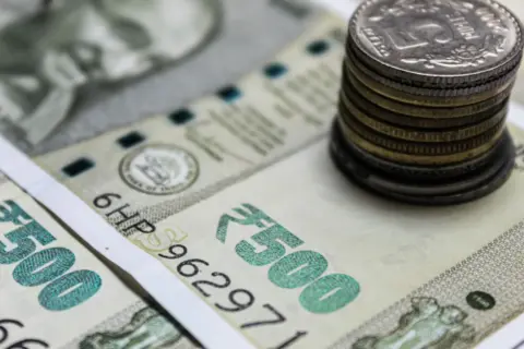 Mandatory Fresh Valuation Under Rule 8(5) - Detailed view of Indian rupees and stacked coins, representing currency and finan