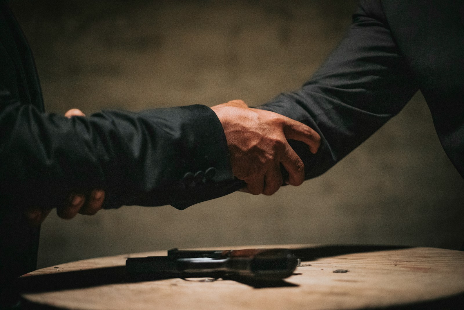 two people shaking hands over a wooden table - doctrine of merger