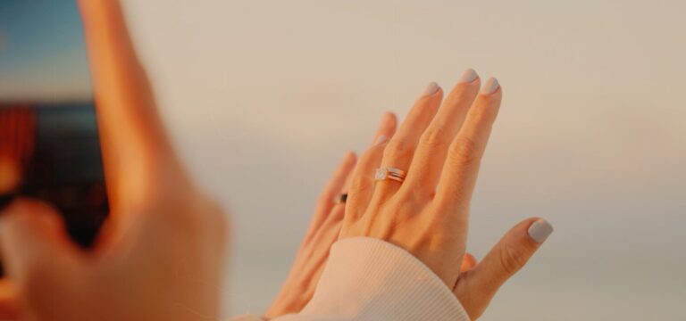 a woman's hand holding a cell phone up in the air