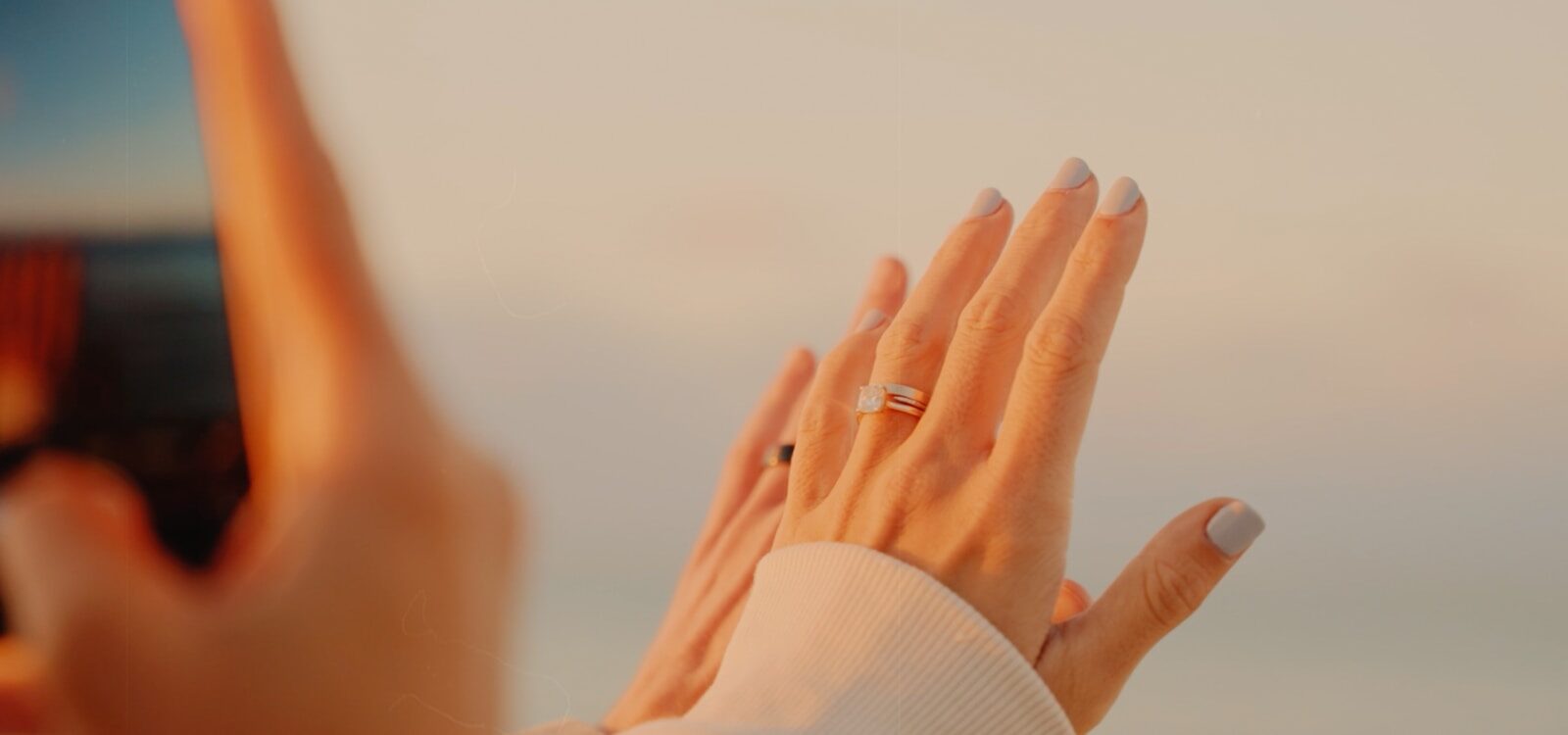 a woman's hand holding a cell phone up in the air