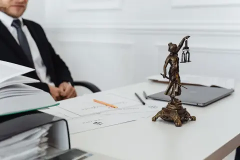 No Trade License, No Bar: Calcutta - A legal professional's workspace featuring Lady Justice statue, documents, and a laptop.