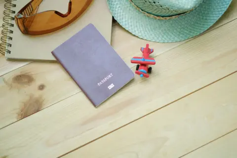 Passport Is A Civil Document, Mere - Flat lay of travel essentials including passport, notebook, toy airplane, sunglasses, an