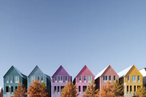 Protecting Homebuyers over Authority Profits: Supreme - Colorful houses line a bright blue sky