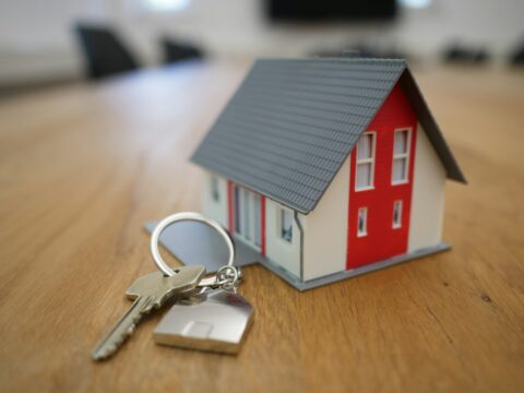 white and red wooden house miniature on brown table - Property Law
