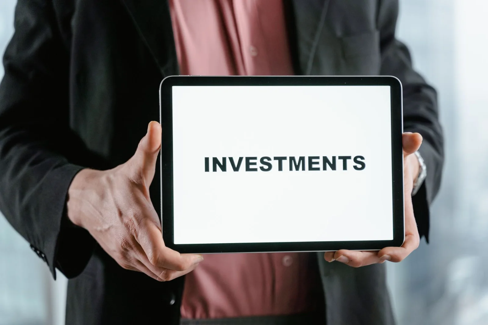 SEBI’s Strategic Shift: Balancing Professional Competence - A businessman in a suit holds a tablet displaying the text 'INVES
