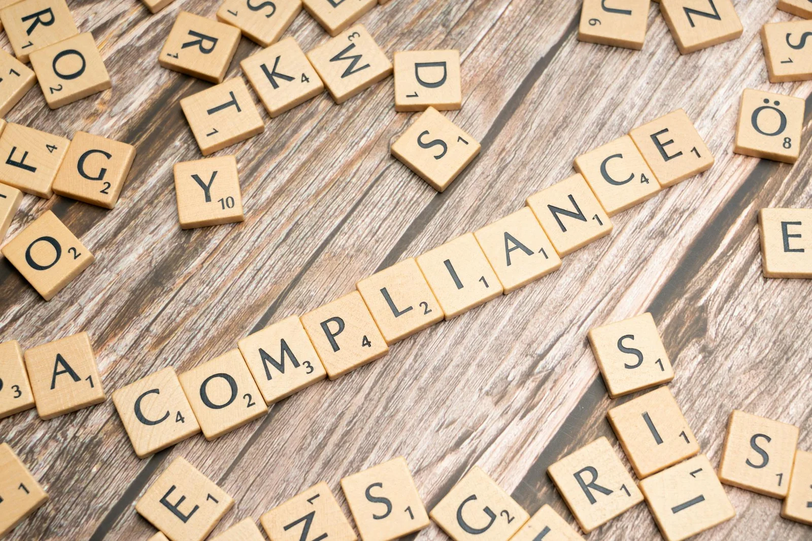cdsl kyc validation circular may 2026 - Wooden letter tiles forming the word 'COMPLIANCE' on a rustic wooden background.