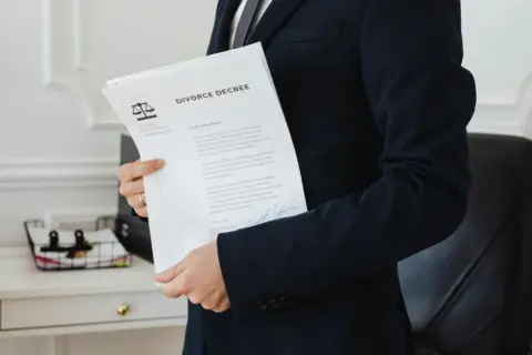 interlocutory res judicata partition suit - - A person holding a divorce decree in an office setting, symbolizing legal proce