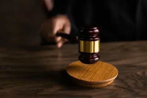 departmental inquiry POSH Act ICC - - A gavel striking a sound block, symbolizing justice and legal authority in a courtroom