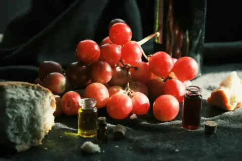fssai food product standards draft amendments - A rustic display of grapes, bread, and wine bottles, accentuated by soft ligh