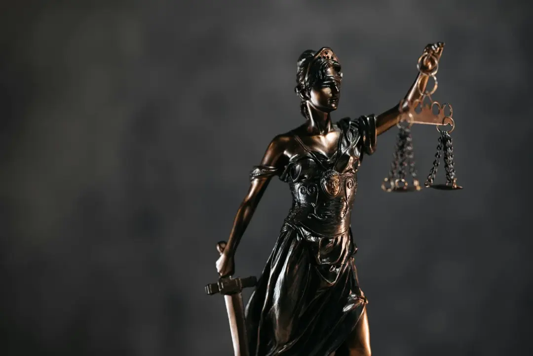 allahabad high court - Arbitration Through - Detailed bronze Lady Justice statue with scales and sword against a dark backgro