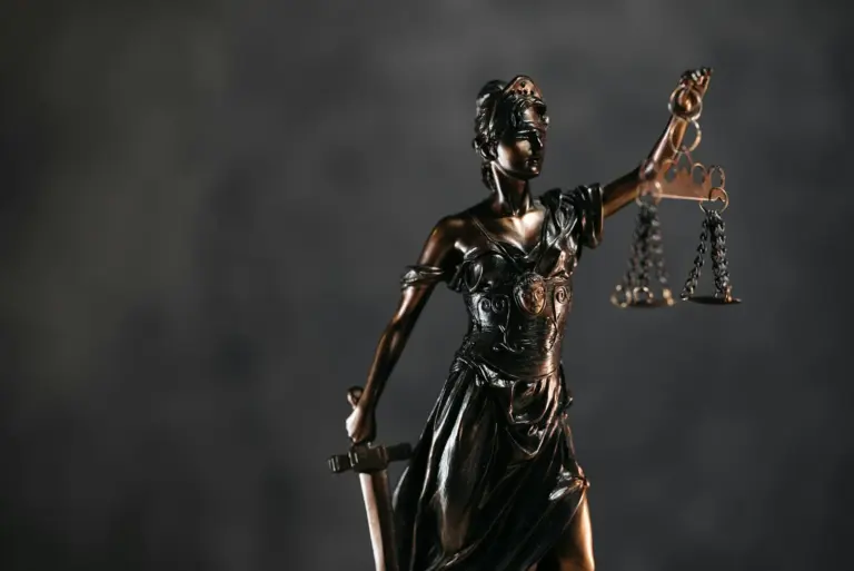 allahabad high court - Arbitration Through - Detailed bronze Lady Justice statue with scales and sword against a dark backgro