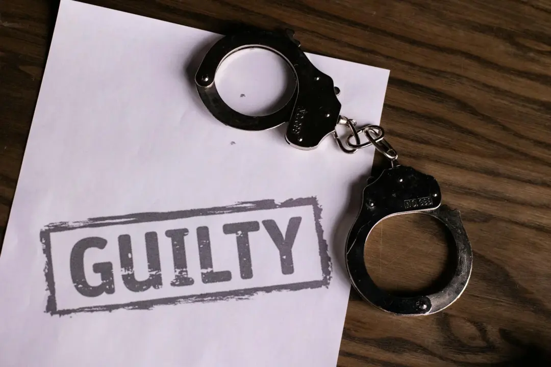 compounding section 138 after conviction - - Top view of handcuffs on paper with 'GUILTY' text, symbolizing a verdict or crim