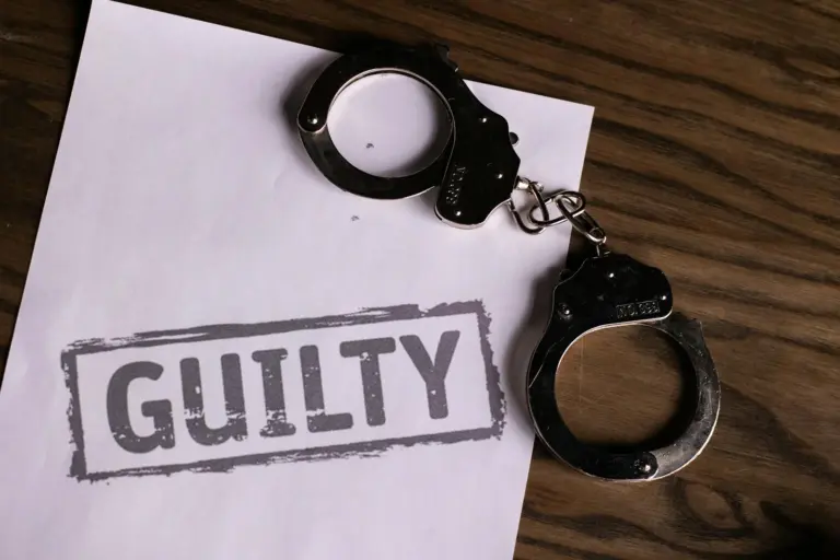 compounding section 138 after conviction - - Top view of handcuffs on paper with 'GUILTY' text, symbolizing a verdict or crim