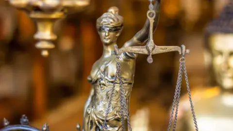 kerala high court body donation rights - A detailed close-up of a Lady Justice statue holding scales, symbolizing law and jus