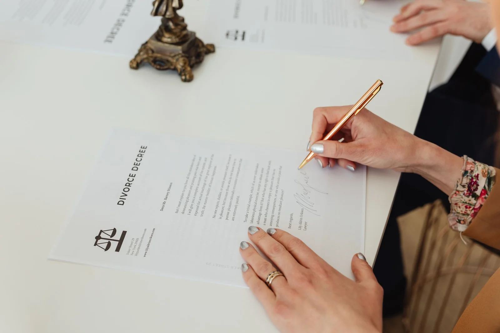 age misrepresentation fraud matrimonial consent - - Close-up of hands signing a divorce decree document on a desk, showcasing