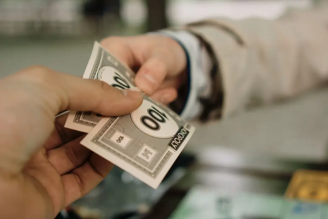 section 13(8) sarfaesi possession notice - - Close-up of two hands exchanging Monopoly money, symbolizing a financial transac