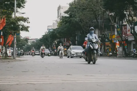 end-of-life vehicle rvsf amendment rules 2026 - A busy street in Vietnam showcasing motorbike traffic, cars, and urban life.