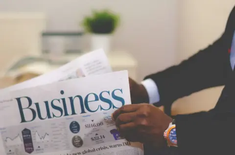 EPFO claims IBC liquidation - Crystallised - Close-up of a businessman reading a newspaper indoors, focusing on business head