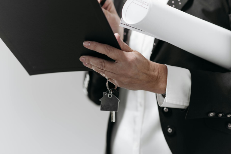 Supreme Court: Residential Sale Deed of - Close-up of a business professional holding a house key and architectural plans, sy