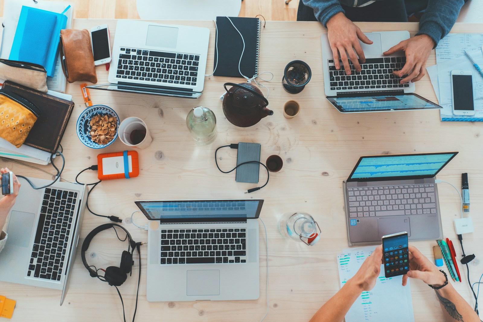 people sitting down near table with assorted laptop computers - Corporate Defamation in Digital Age