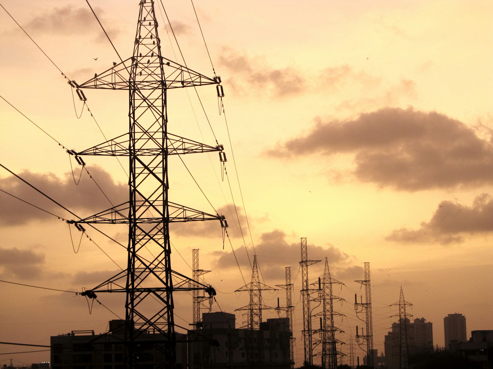 A high voltage power line with a city in the background