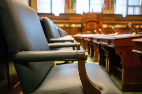 The Auction Purchaser's Right to Be - Elegant courtroom seating with leather chairs and wooden desks, exuding a sense of auth