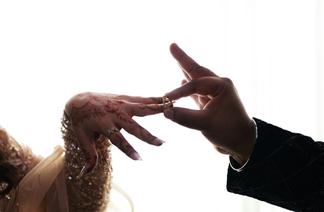 Man places ring on woman's finger