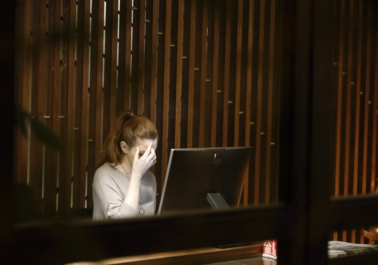 a woman sitting in front of a laptop computer - Night Work Restrictions for Women