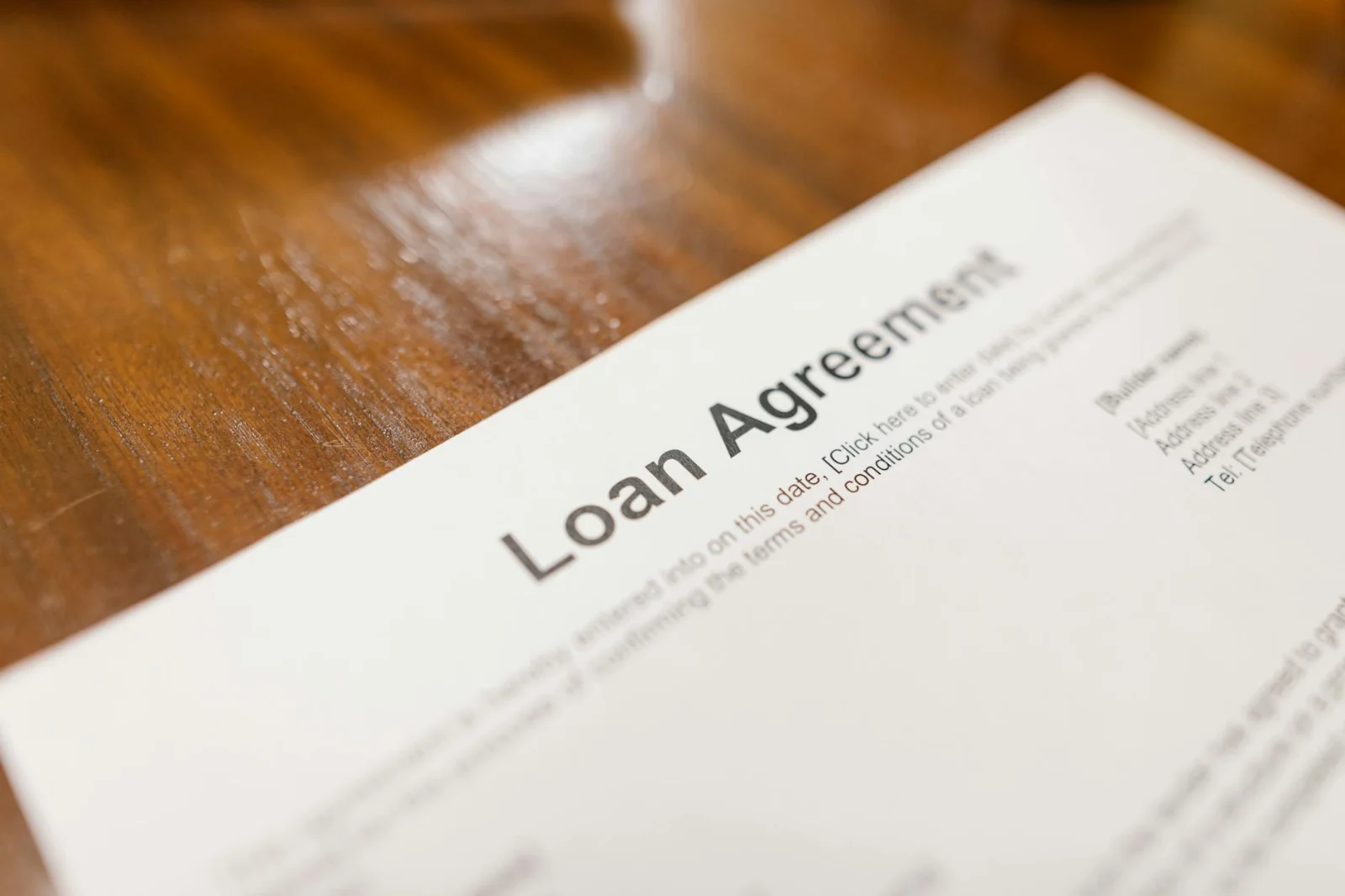 When a Loan Takeover Triggers Statutory - Detailed loan agreement document close-up on a wooden table representing legal and
