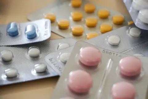 When the Cure Becomes the Threat: - Close-up view of assorted colorful medication blister packs with diverse pills.
