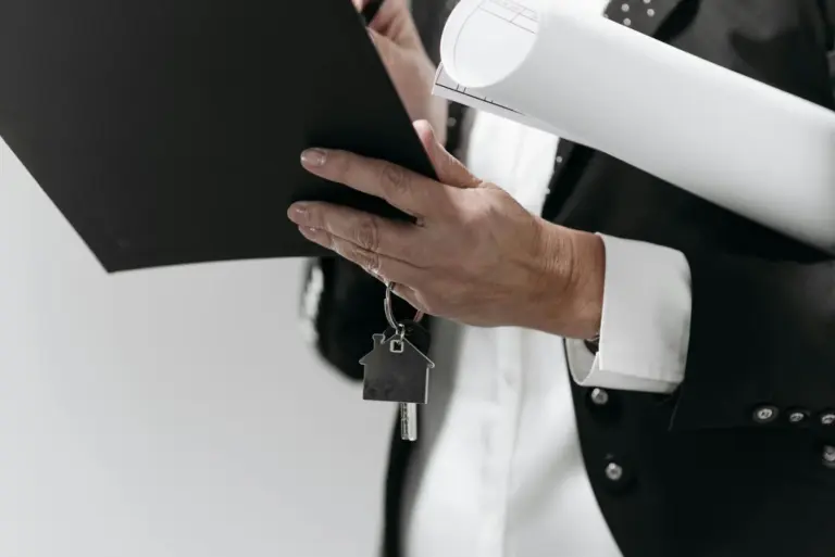 Writ or Tribunal? The SARFAESI Crossroads - Close-up of a business professional holding a house key and architectural plans,